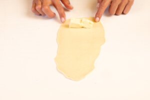 Coloca la mantequilla en la parte más ancha de la masa