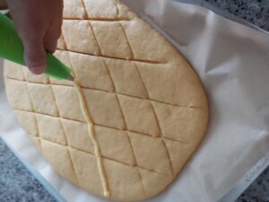 Coloca la crema pastelera sobre los cortes de la masa de coca de san juan