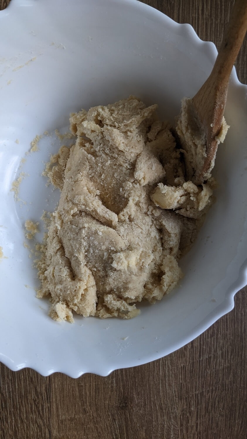 Echa la mezcla del huevo y la nata a la harina con la mantequilla y mézclalo con la ayuda de una cuchara de madera.