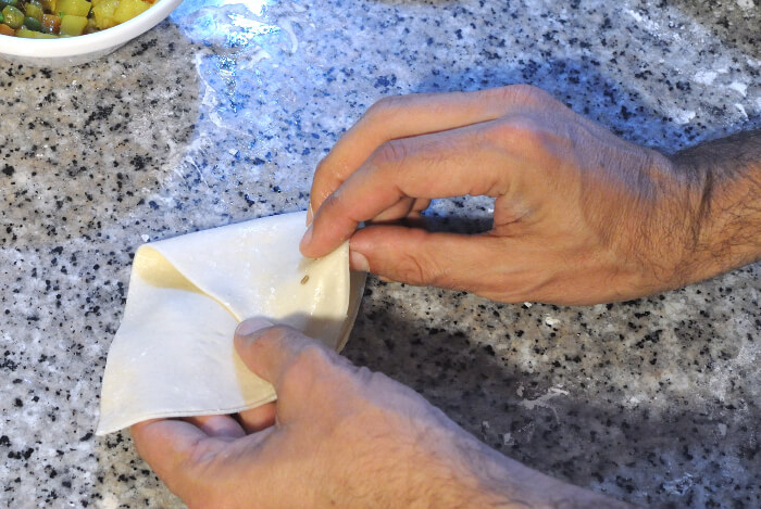 Pliega la masa de las samosas para hacer un cono